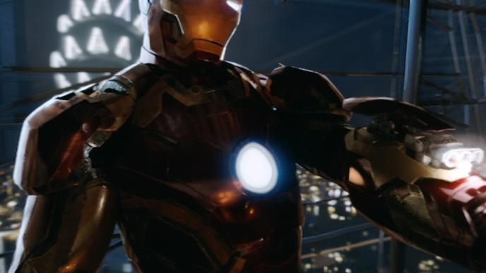 front view of iron man posing with left arm out. the empire state building is lit up as the night city skyline twinkles in the background