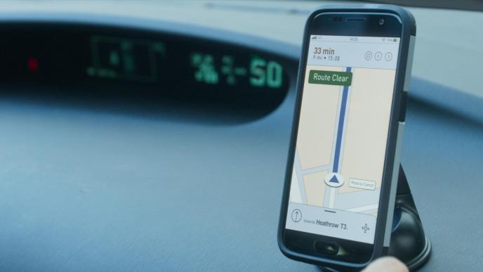 a phone propped up on a car dashboard