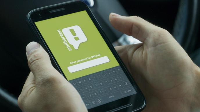 a pair of hands holding a phone that has a smithereen branded social media password entry landing page