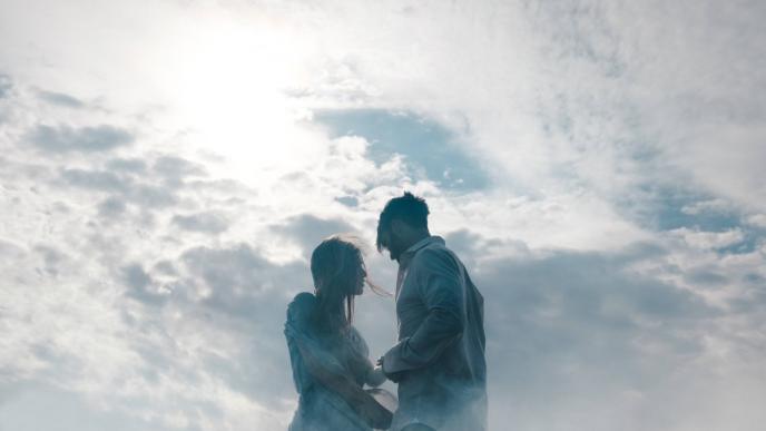 a couple holding hands while facing eacb other
