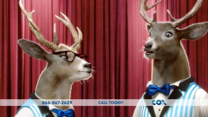 two cg animated bucks wearing striped quintet suits looking at each other in front of a red stage curtain