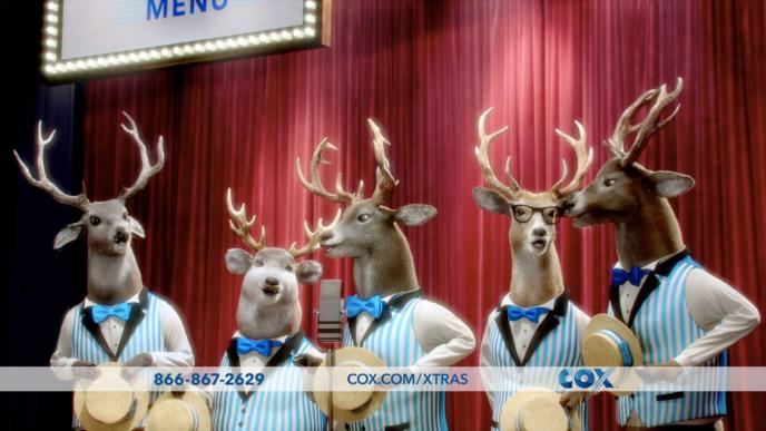 front side view of cg animated five reindeer bucks wearing striped quintet suits singing in front of a red stage curtain