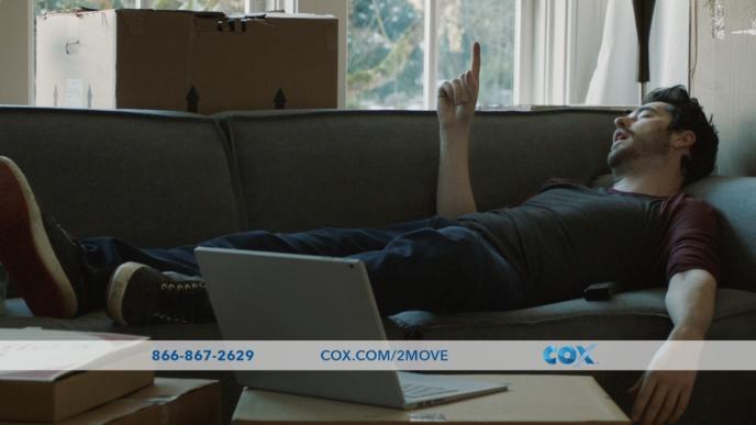 a person sleeping on a sofa with their index finger pointing upwards