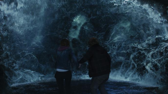 back view of hermione granger and ron weasley standing in the chamber of secrets as voldemort's horcrux face emerges through waves of water
