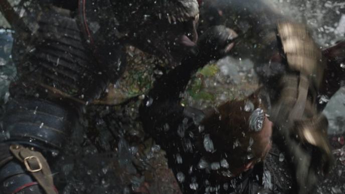 a reptile monster grabbing a man as glass smashes around them