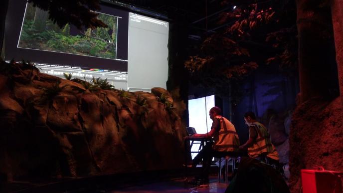 two people sitting down looking at a screen in an immersive ride game