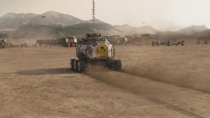 a spacecraft rover driving towards a station amongst mountainous terrain on planet mars