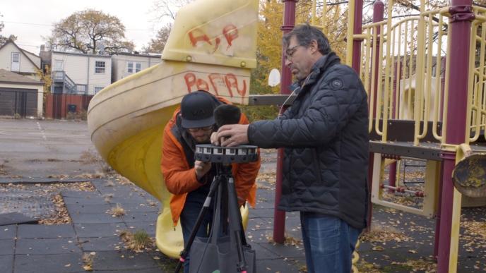 film crew setting up a 360 camera in a children's park