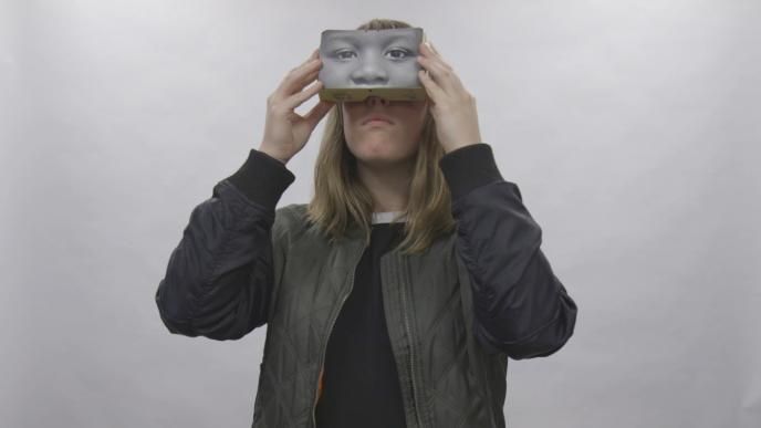 a woman holding up a vr headset to her face