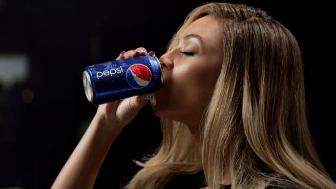 woman drinking out of a pepsi can
