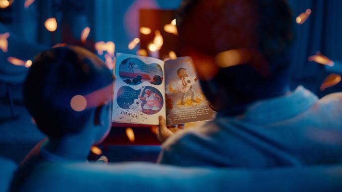 back view of a father and son reading a bedtime story