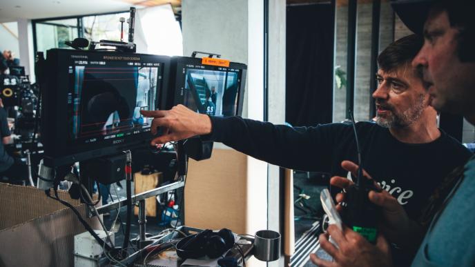 directors looking at a screen behind the scenes