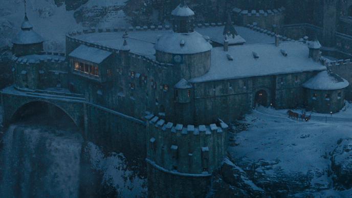 mountain-side castle shirburn castle covered in snow with a water fall from sherlock holmes game of shadows