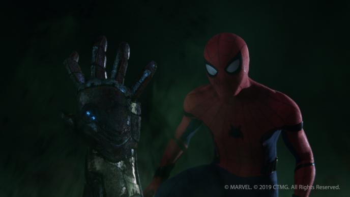 the zombified arm of iron man sticking out of the image as spider man stands towards the right