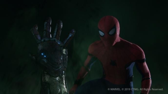the zombified arm of iron man sticking out of the image as spider man stands towards the right