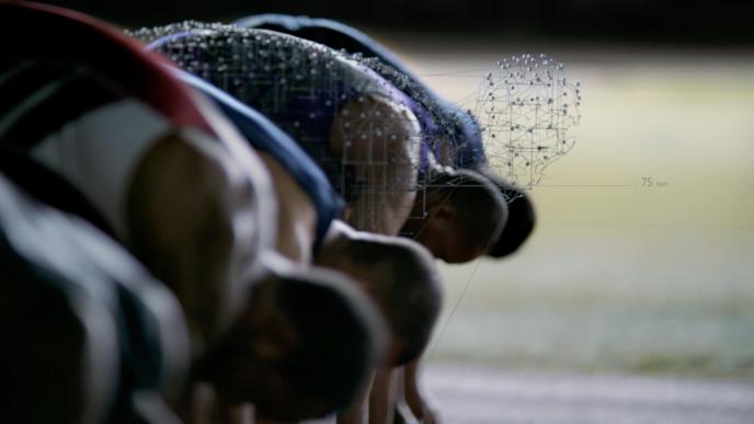 runners waiting in a set position before a race. there is one runner made up of dynamic graphic designs