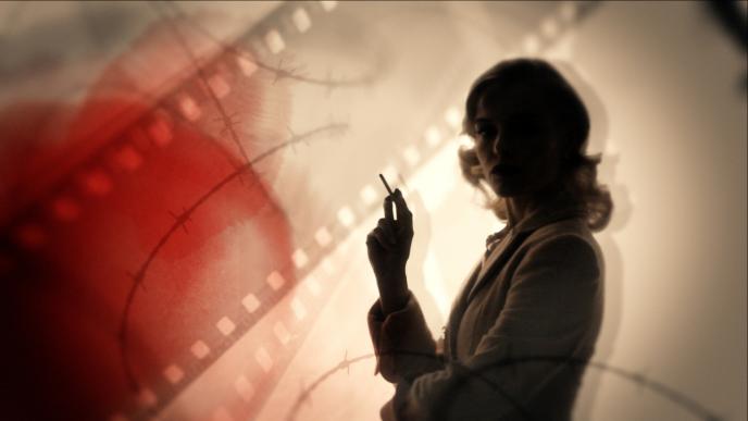 silhoutte of an actress holding a cigarette in her hand as photography film and barbed wire is juxtaposed on the background