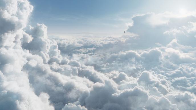 a bright and sunny blanket of clouds in the troposphere as a hot air balloon flies in the distance