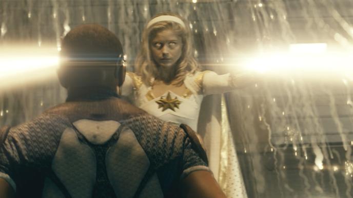 back view of actor laz alonso as character mother's milk standing in front of actress erin moriarty as character annie january as annie january shoots out light from her hands with whitened eyes and sparks around her