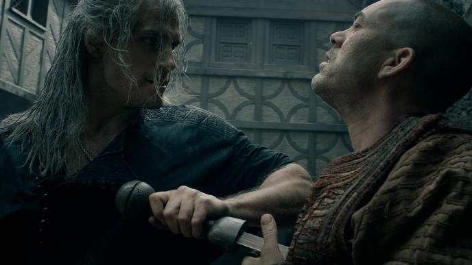 henry cavill as the witcher stabbing a person