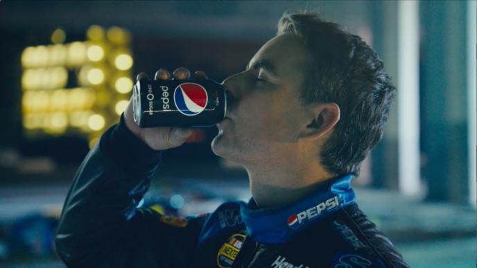 a race car driver wearing a pepsi branded suit, drinking a can of pepsi