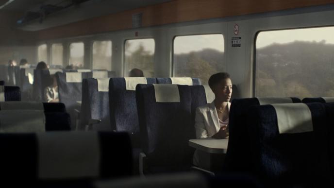 person sitting alone in a train looking out the window