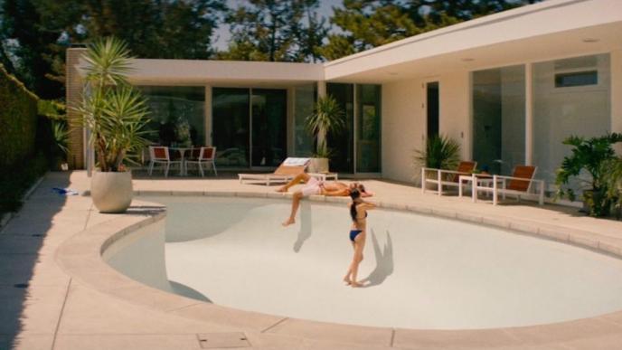 a couple hanging out by an empty swimming pool