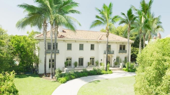 front view of a pasadena mansion surrounded by palm trees