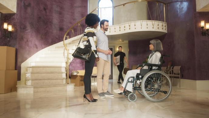 actress lucy liu aged through cg animation sitting in a wheelchair as two people stand before her and another person is walking towards them inside a pasadena mansion