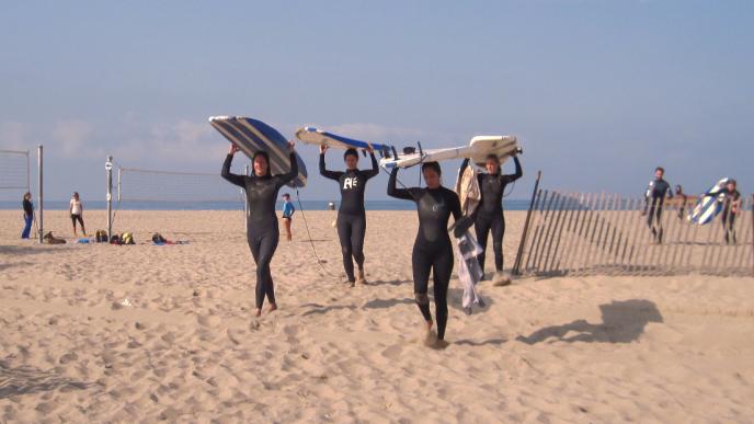 The surfbroads walk along the beach