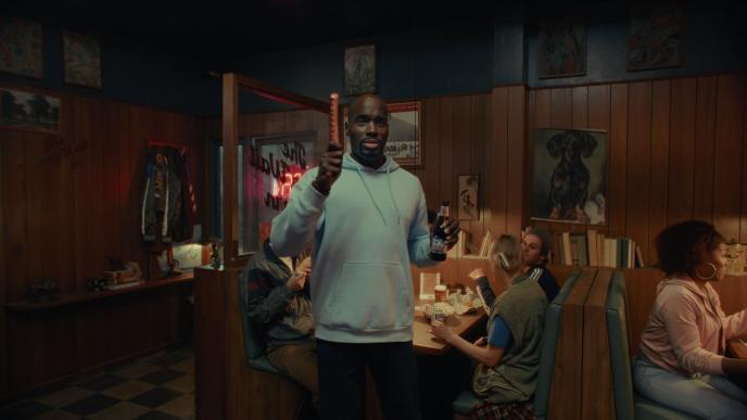 A man holding a beer in a crowded bar