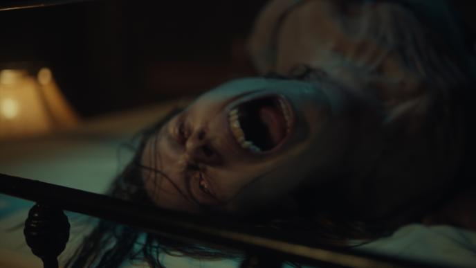 A woman screaming, seemingly in pain, lying down