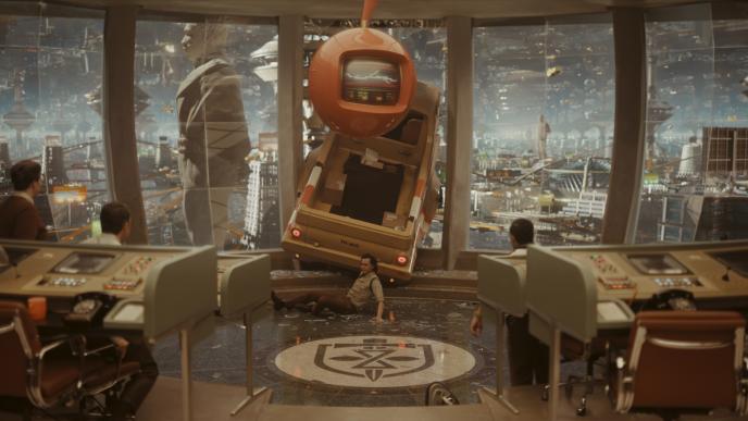 Loki crashes a flying truck through a window in the TVA, landing on the floor in front of a bay of desks
