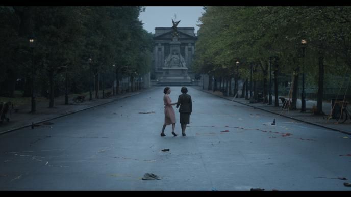 Two women walking down a wide park path