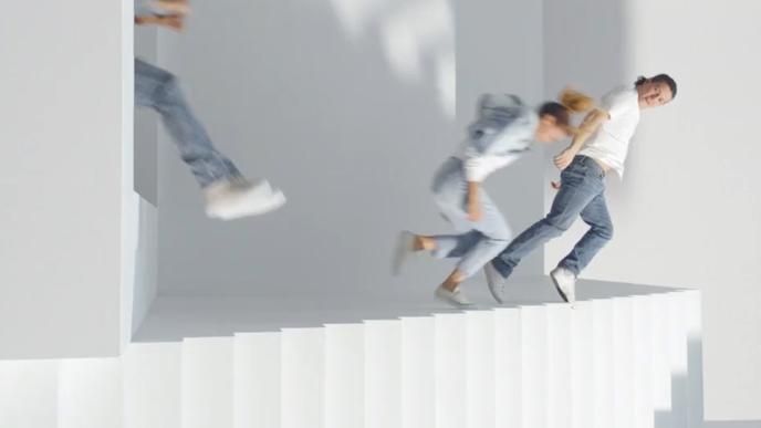 A woman and a child are jumping off a set of stairs that a laying their side.