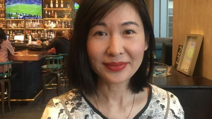 A headshot of Hong Yane Wang wearing a black and white shirt. 
