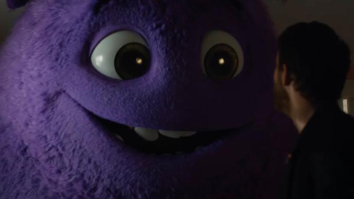 A large purple fluffy monster speaking to Ryan Reynolds