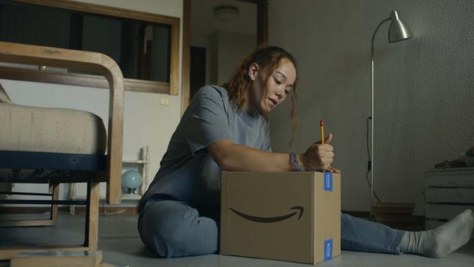 A women in her flat opening an Amazon Prime parcel 