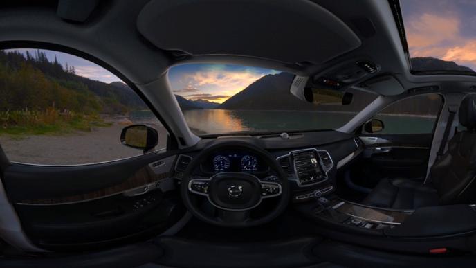 The interior of a Volvo car showing a beautiful landscape outside the windows.