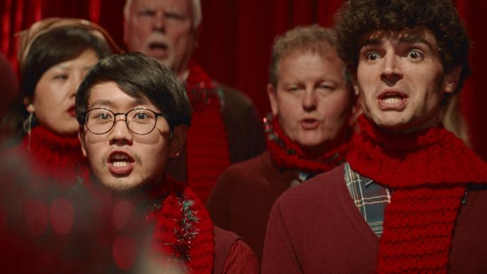 Men in red sweats and red scarves singing