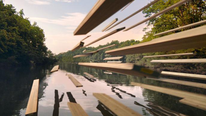 Wood boards soar over a calm lake surrounded by trees