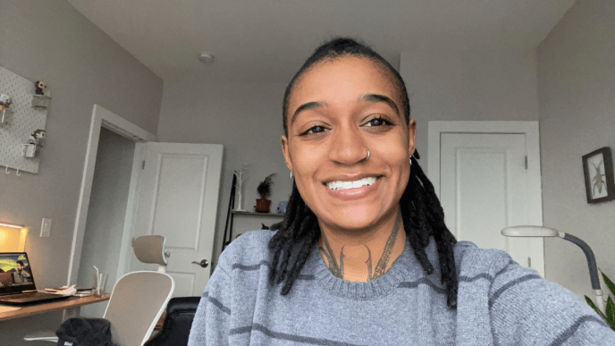 A black woman smiling in a selfie taken in her kitchen.