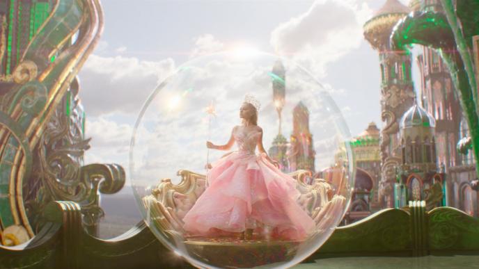 Ariana Grande as Glinda, in a large pink dress, inside a bubble