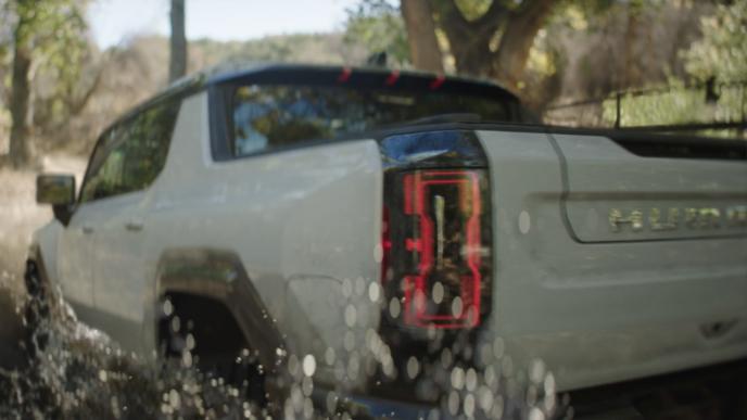 A Hummer truck drives through the water
