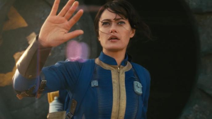 A woman in a lightweight space suit holds up her hand