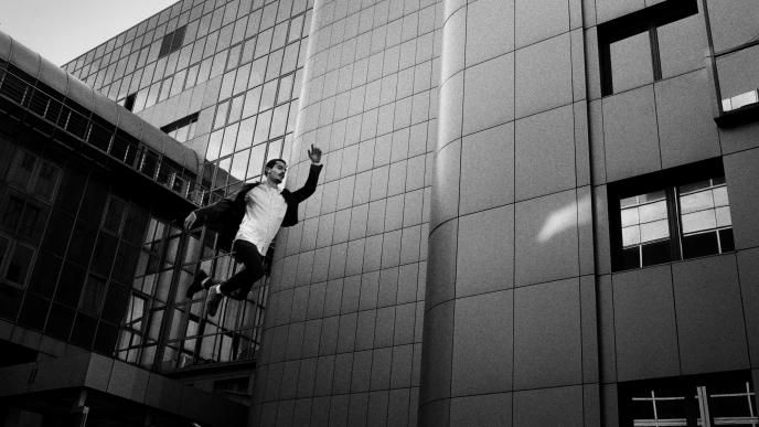 A black and white photo of a man jumping through the air 