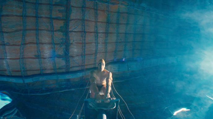 A man about to dive into a pool seen from under the water.