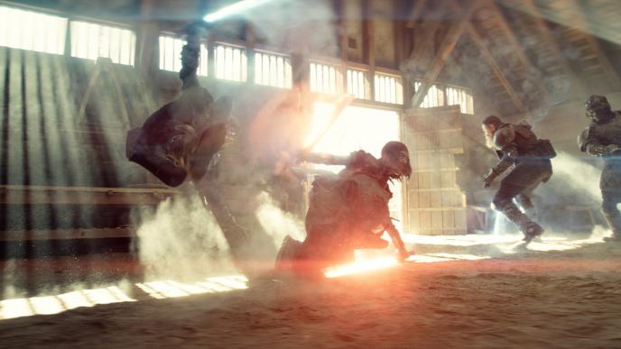 A group of people fighting with glowing swords, they are jumping through the air and ducking close to the ground.