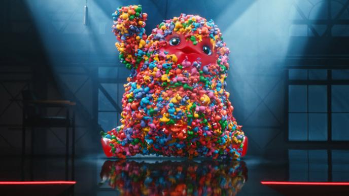 Nerds Gummy Monster strikes a pose on a stage with spotlights on him