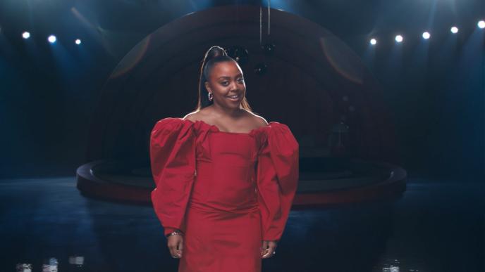 Quinta Brunson standing in a red dress